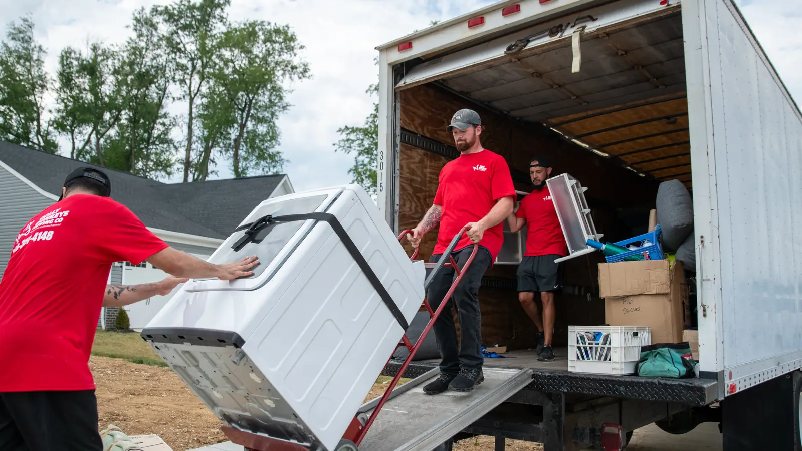 The Dolly Donkeys crew unloading an appliance down the truck ramp