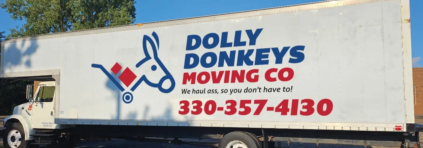 The Dolly Donkeys box truck with the company logo and slogan painted on the side