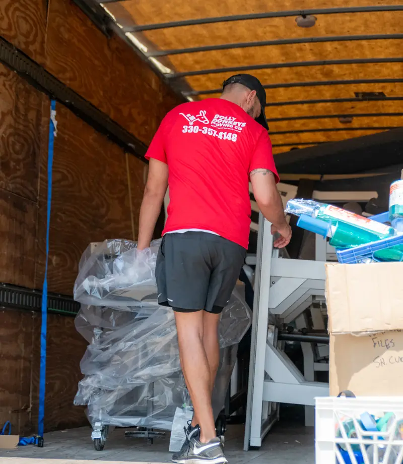 A Dolly Donkeys mover loading office equipment into the truck