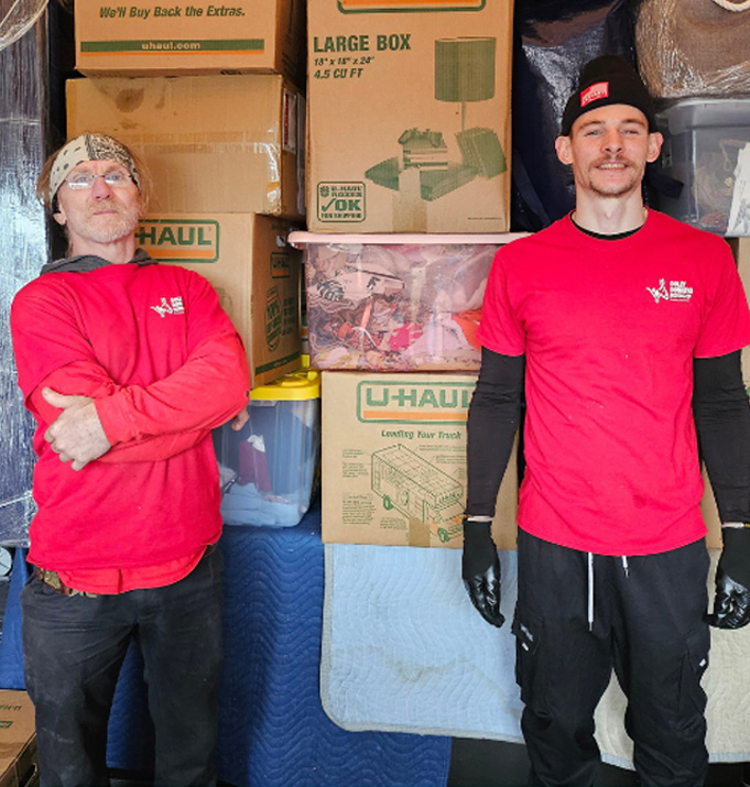 Two Dolly Donkeys movers with a truck loaded full of boxes and hauled-away items